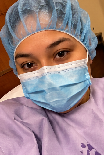 Gaby wearing a surgical gown and mask on the day of her bariatric surgery.